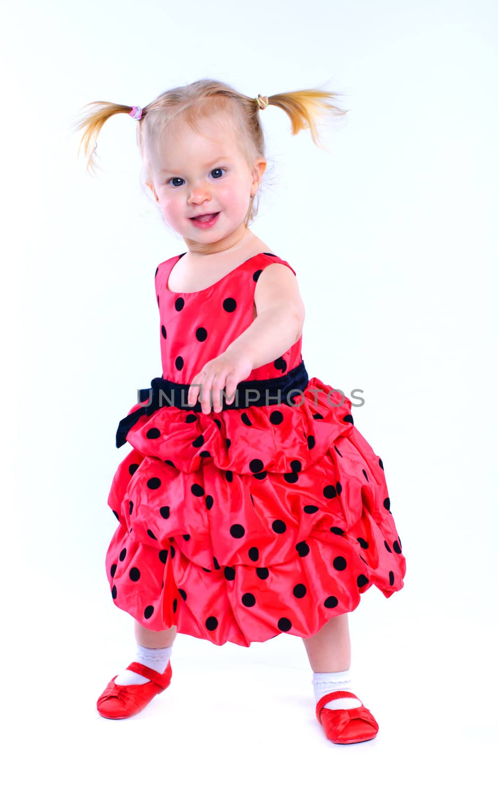 Cute little girl in a red dress. In the studio. Isolated by maxoliki