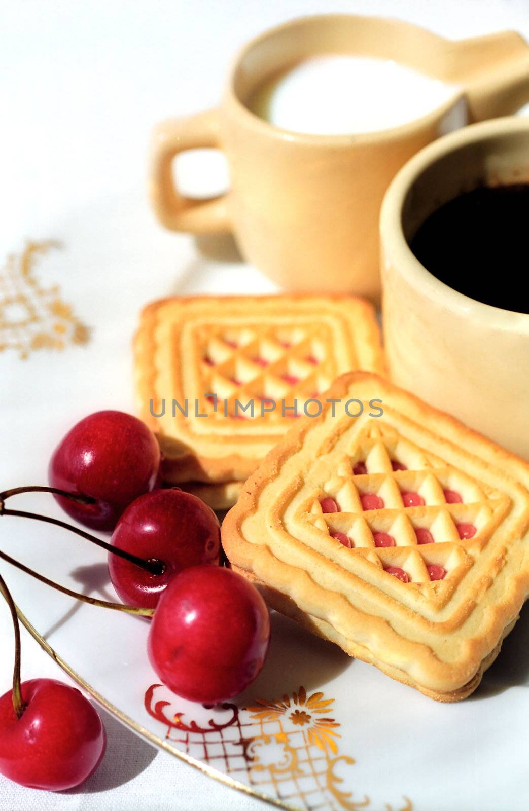 Cherry and biscuit on the plate with cups of coffee and cream