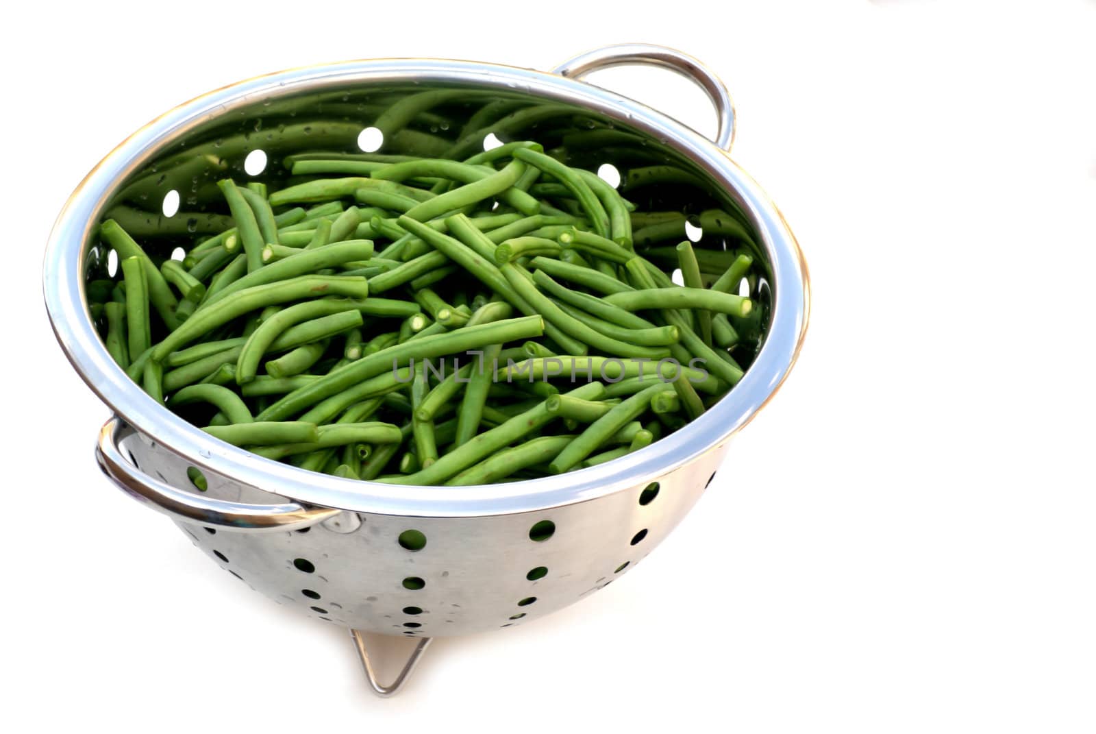 An isolated strainer filled with french beans.