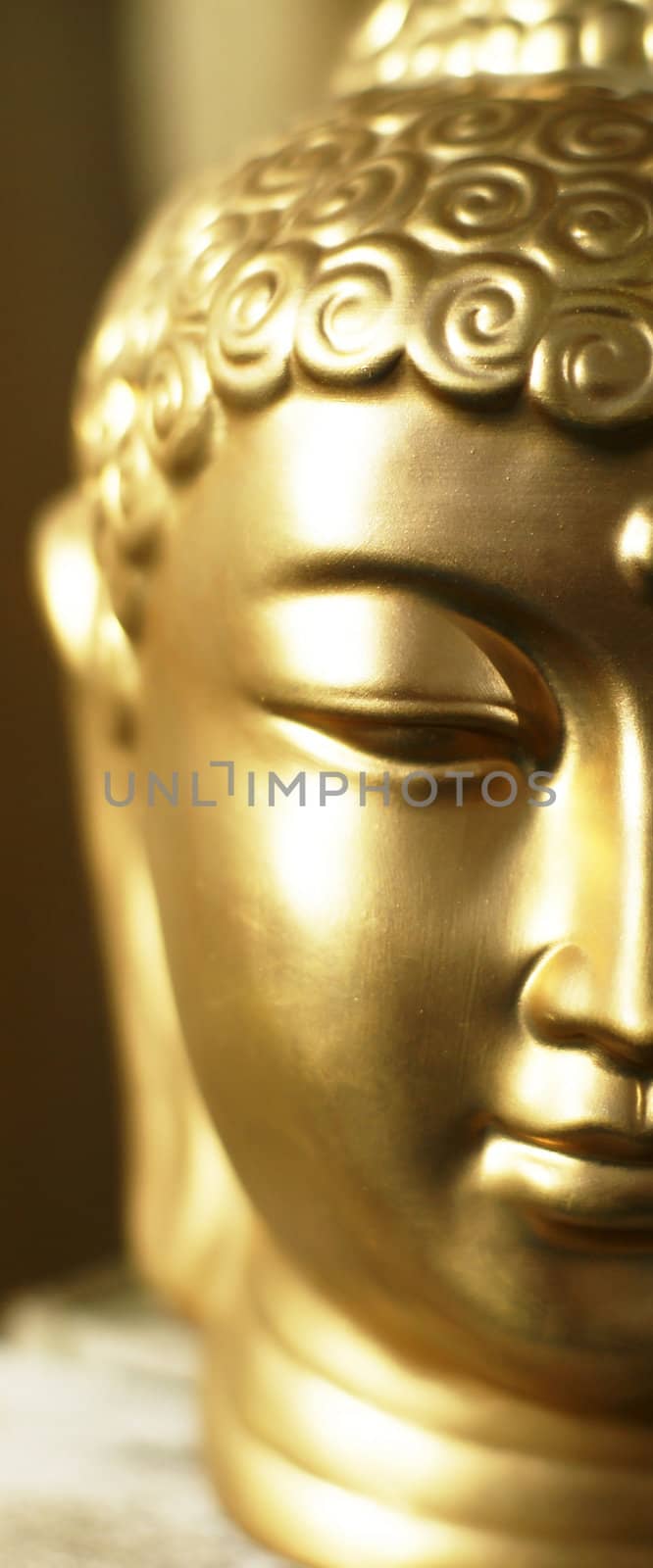 Half the head of a golden buddha in a warm (atmos)sphere.