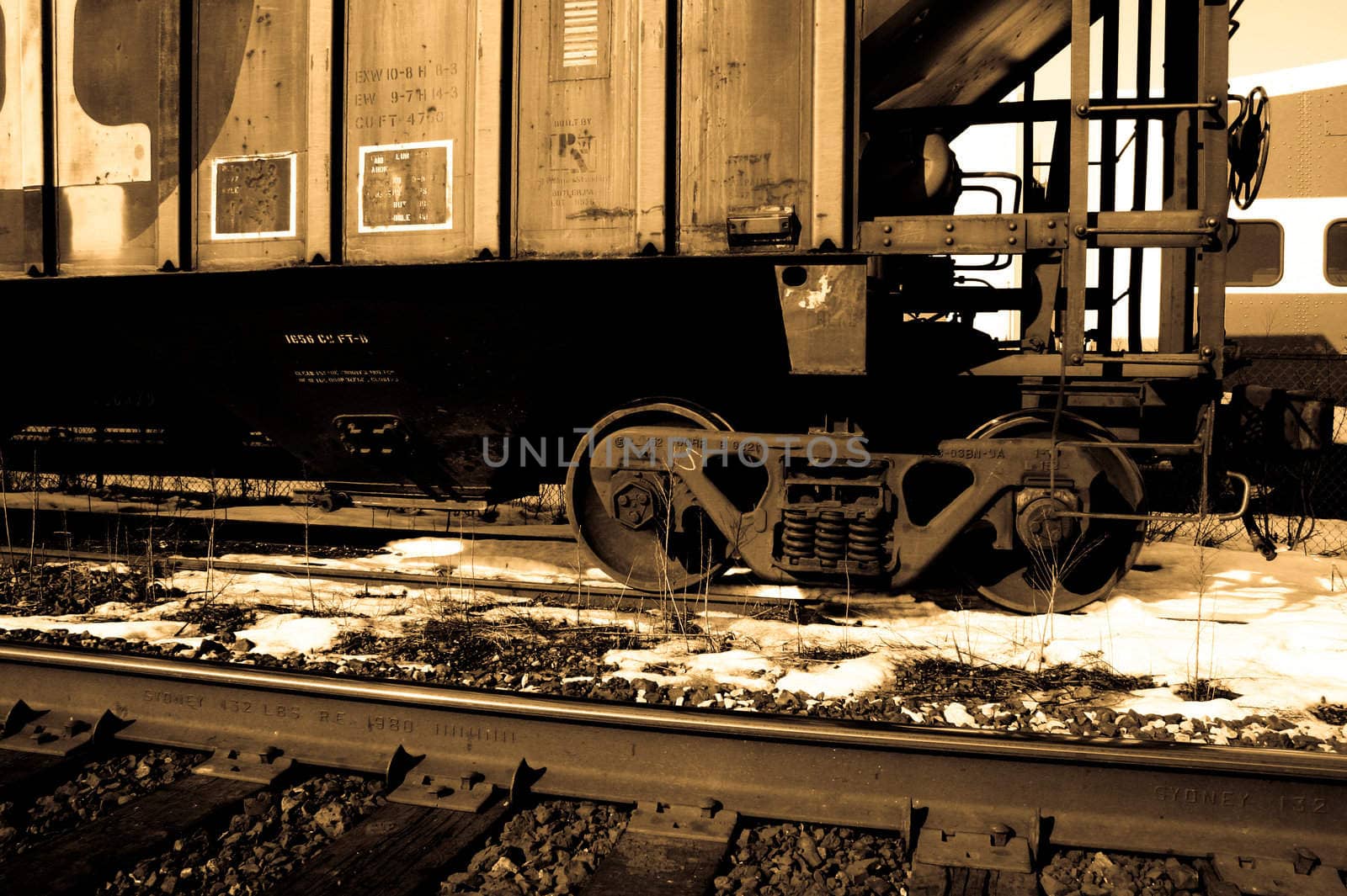 Sepia tone photo of a railroad car sitting on the tracks.