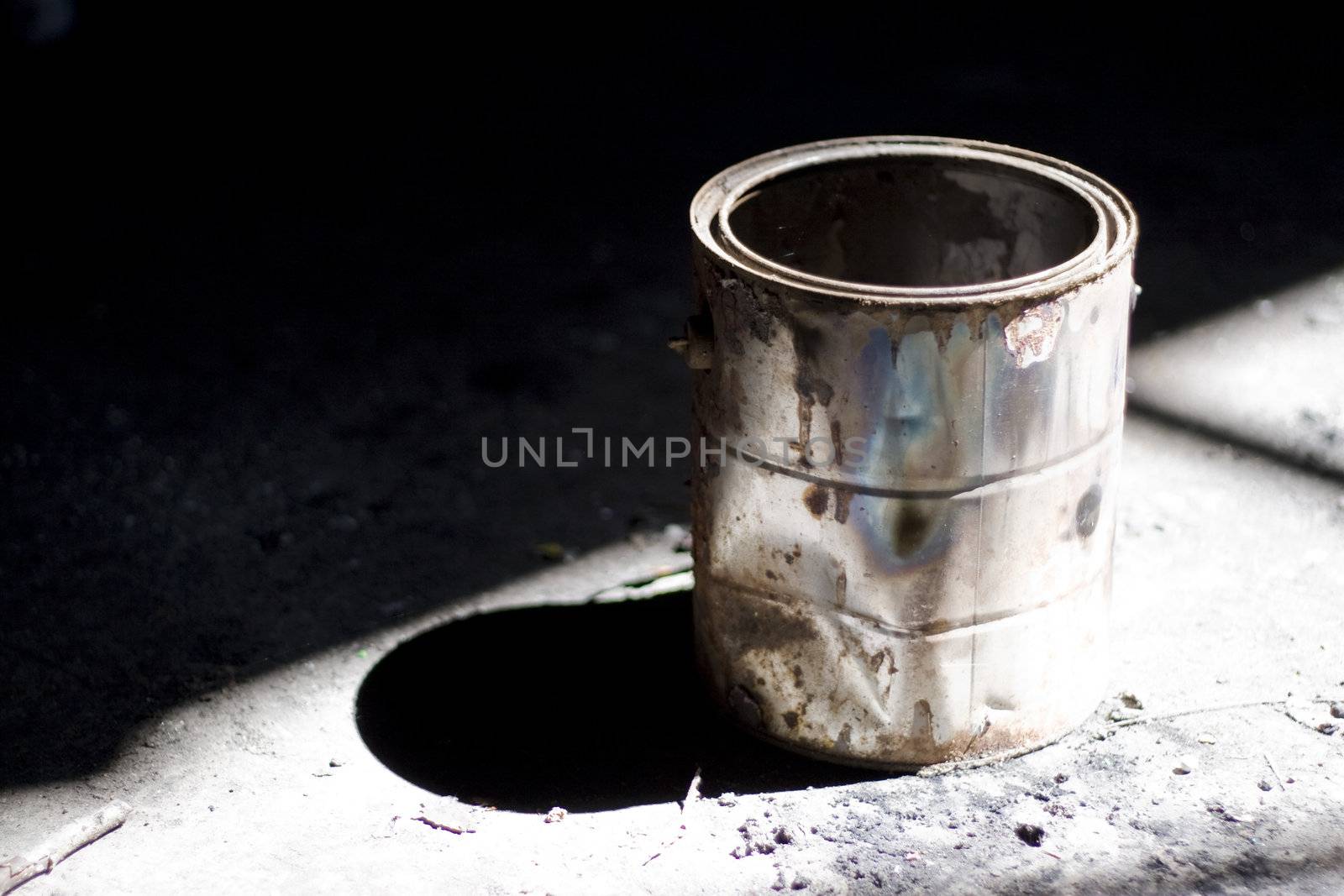 Still life shot of a rusty old paint bucket under dramatic lighting.