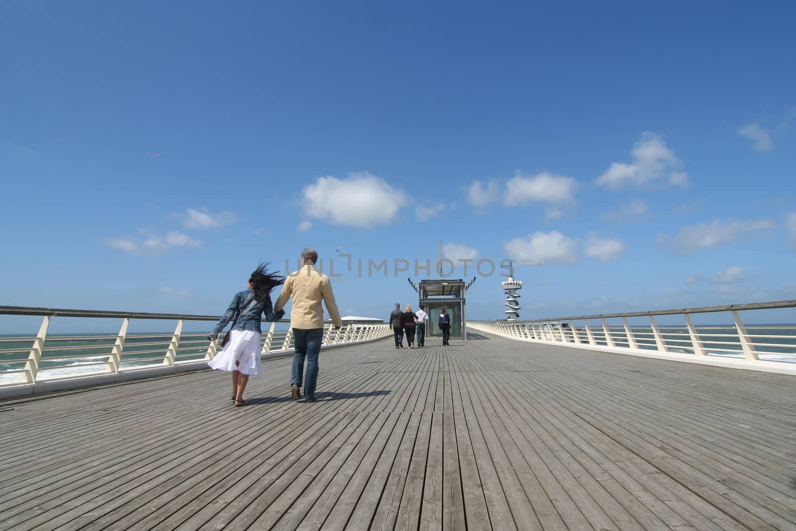 Couple and other people walking on a pier