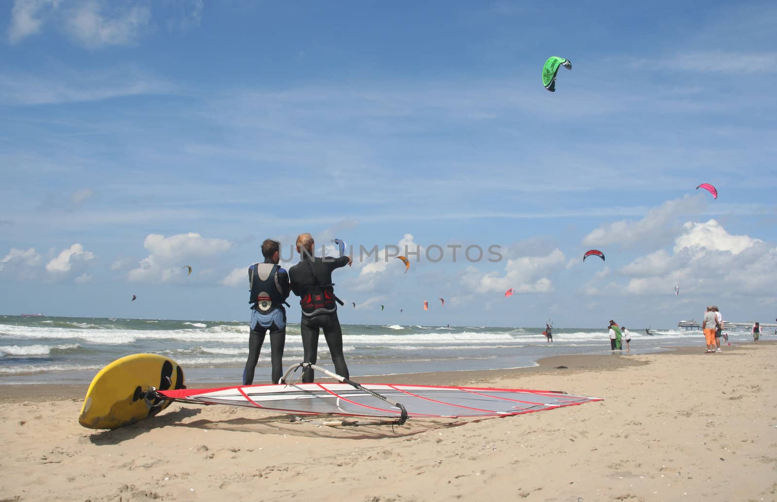 Two surfers watching, one pointing