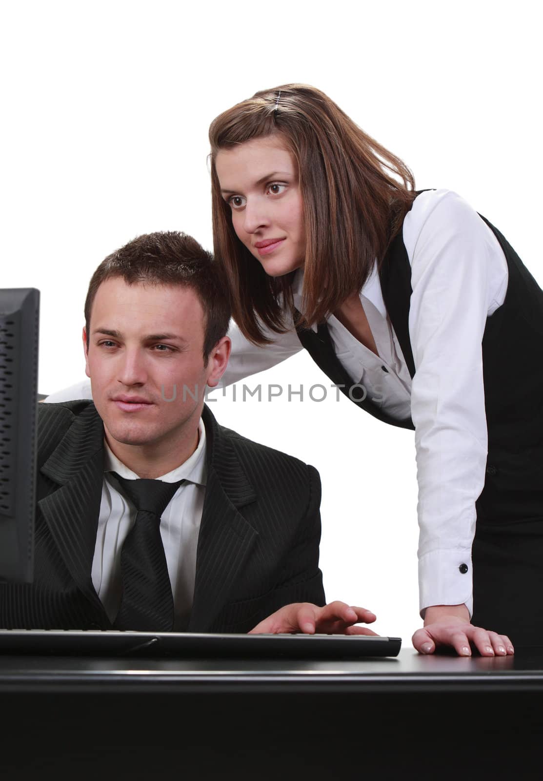 Young couple looking together to a computer, isolated against a white background.