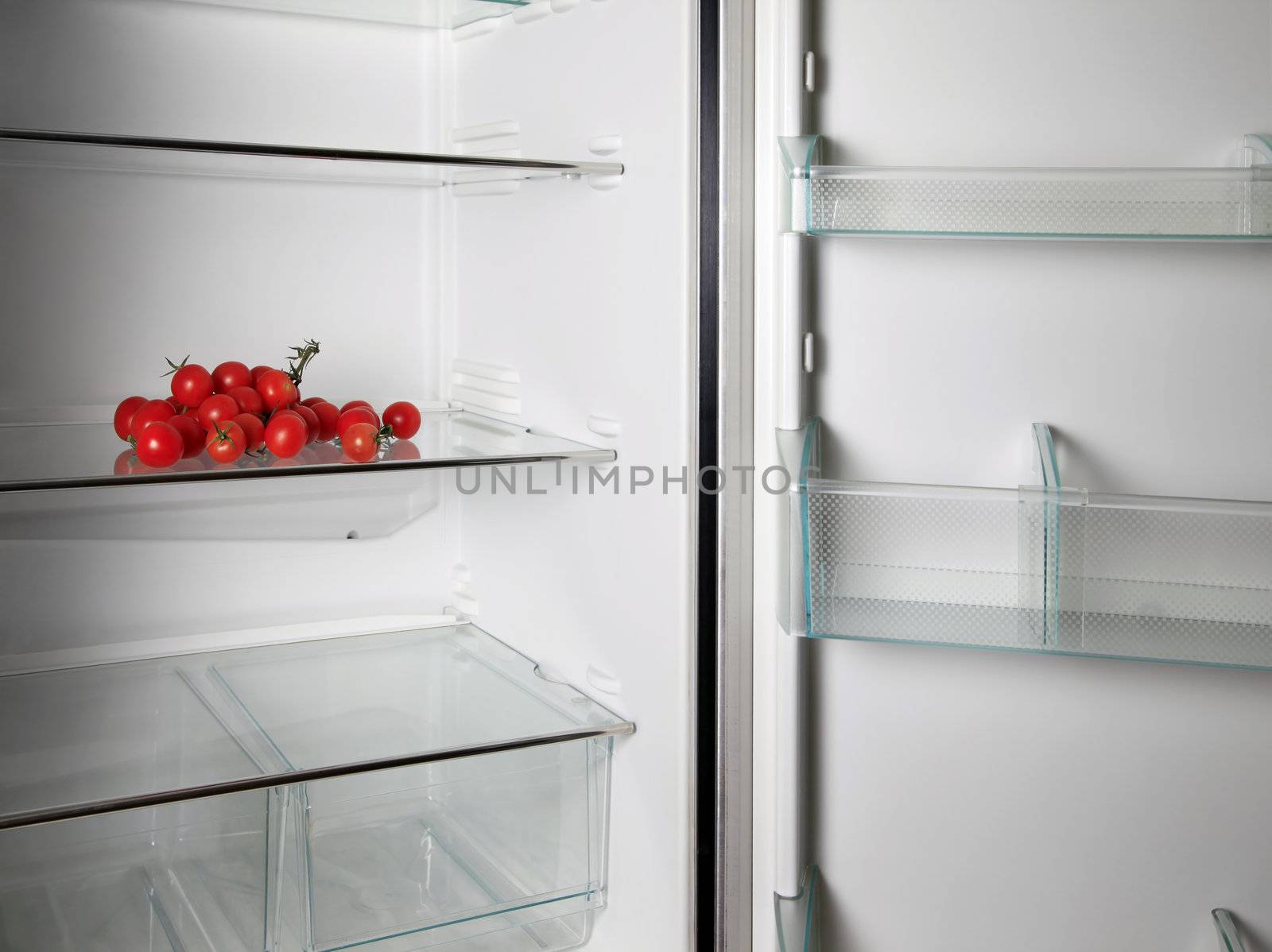 Empty refrigerator with fresh tomatos