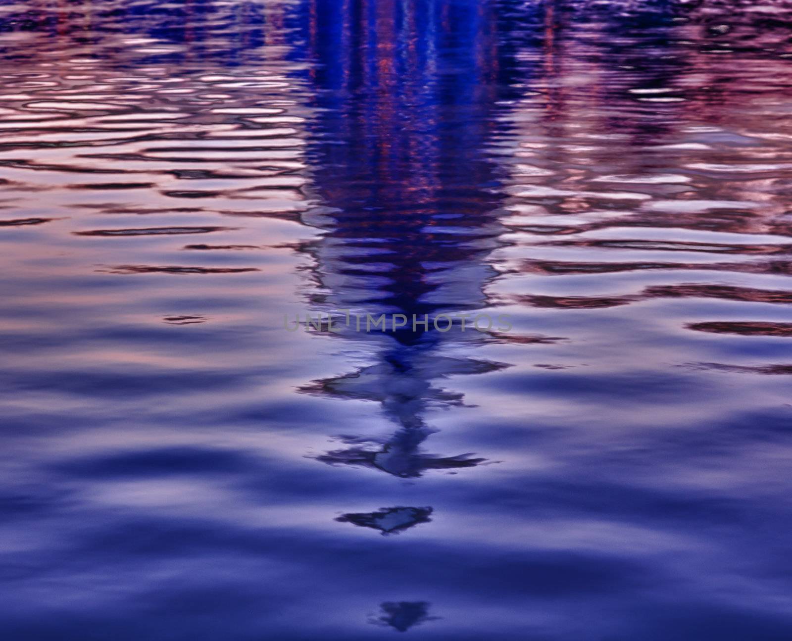 Brightly lit dawn sky behind the illuminated dome of the Capitol in Washington DC reflecting in the water of the pool in front of the building