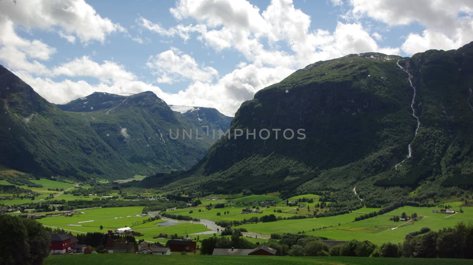 Beautiful Norway landscape with mountain peaks , river and old stone wall