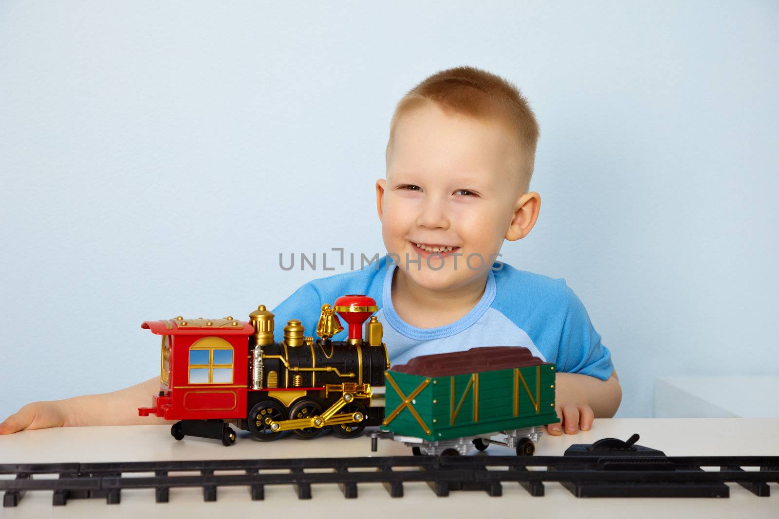 Boy playing with toy railway by pzaxe