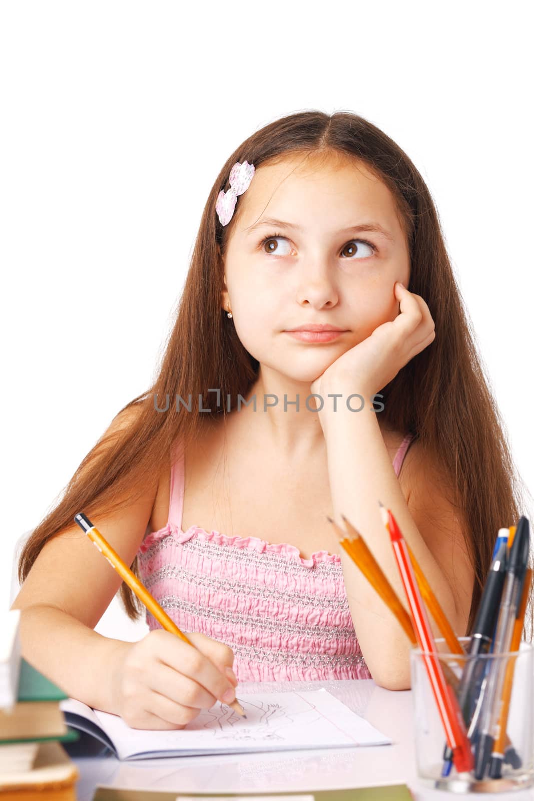 Cute little girl sketching something, holding her hand under her chin, looking away.
