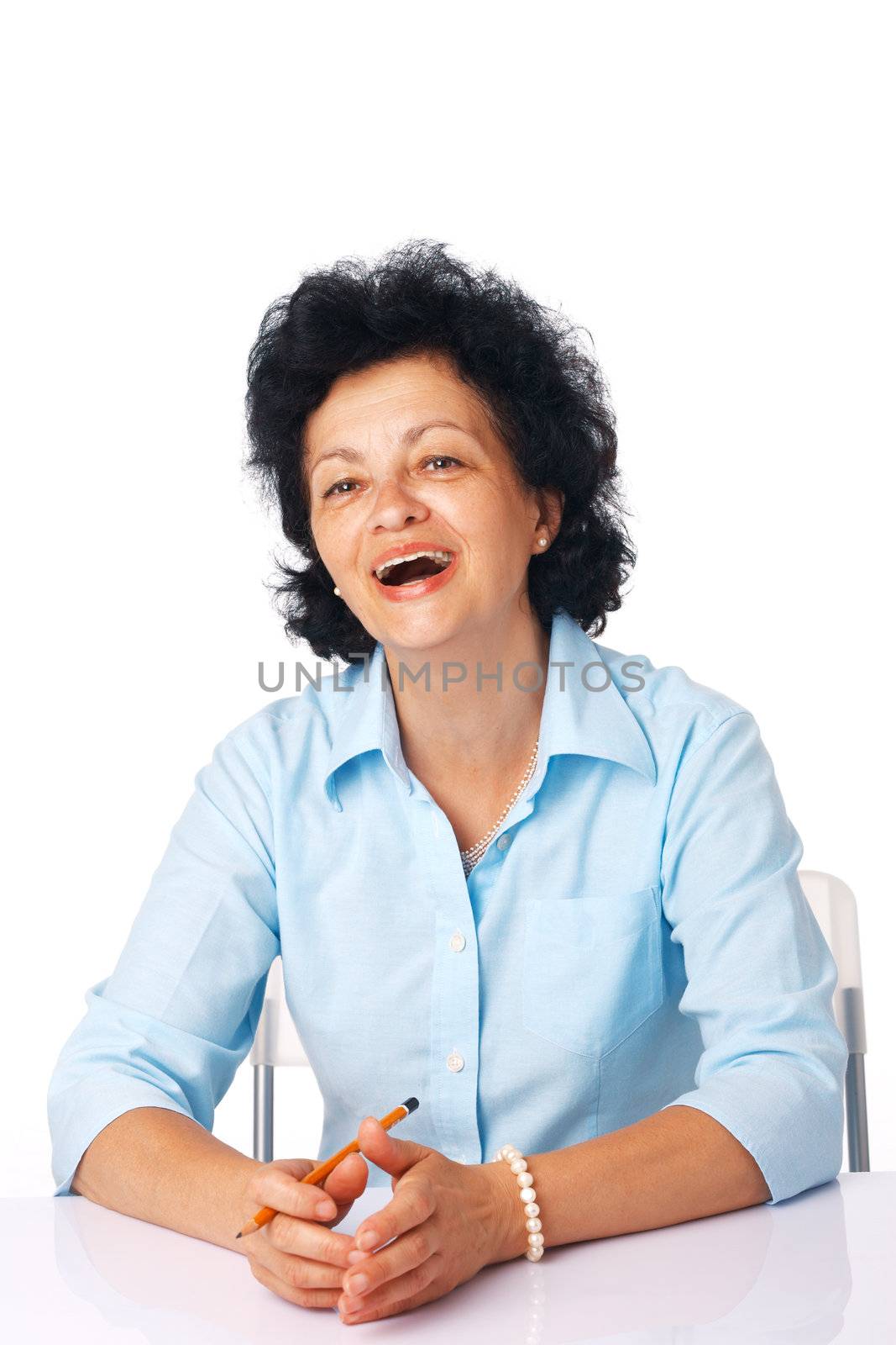 Elder woman smiling and sitting at the table. 