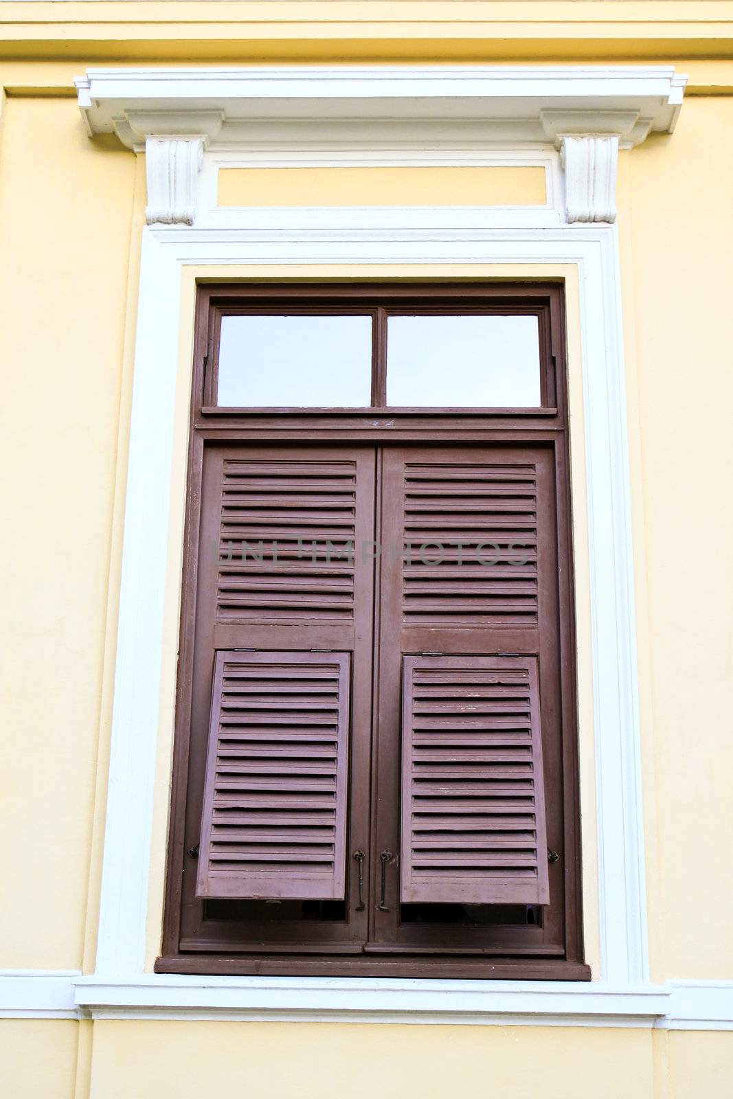 vintage brown window on the yellow wall