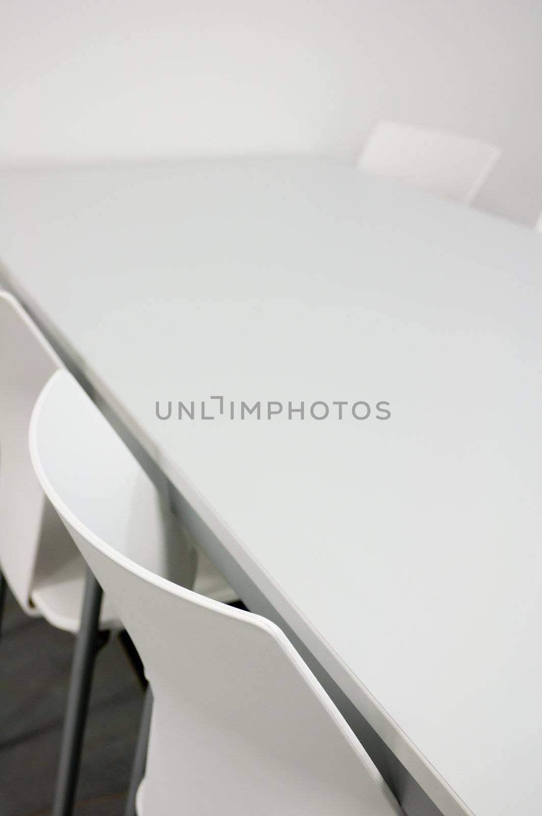 Detail of White Chairs and Table in Empty Meeting Room