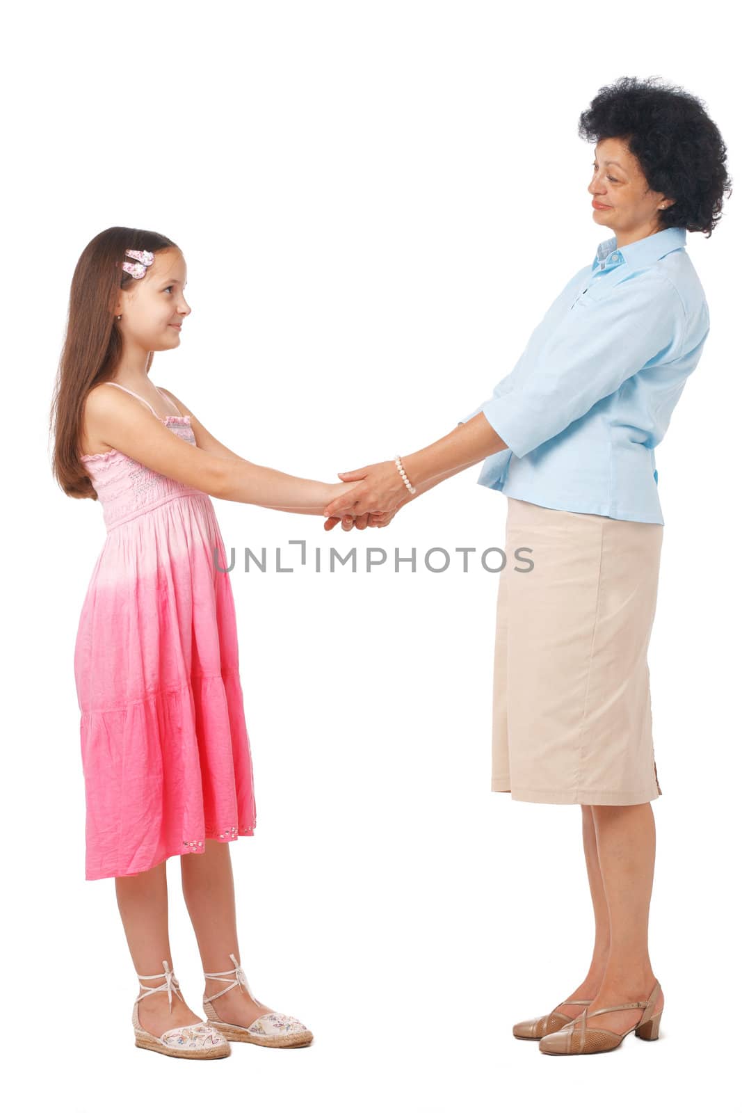 A full length portrait of grandmother holding hands with  her granddaughter. 