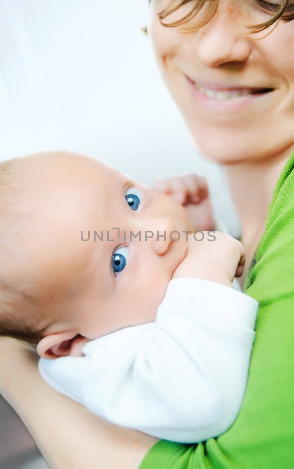 Happy cute infant boy lying on his mother hands