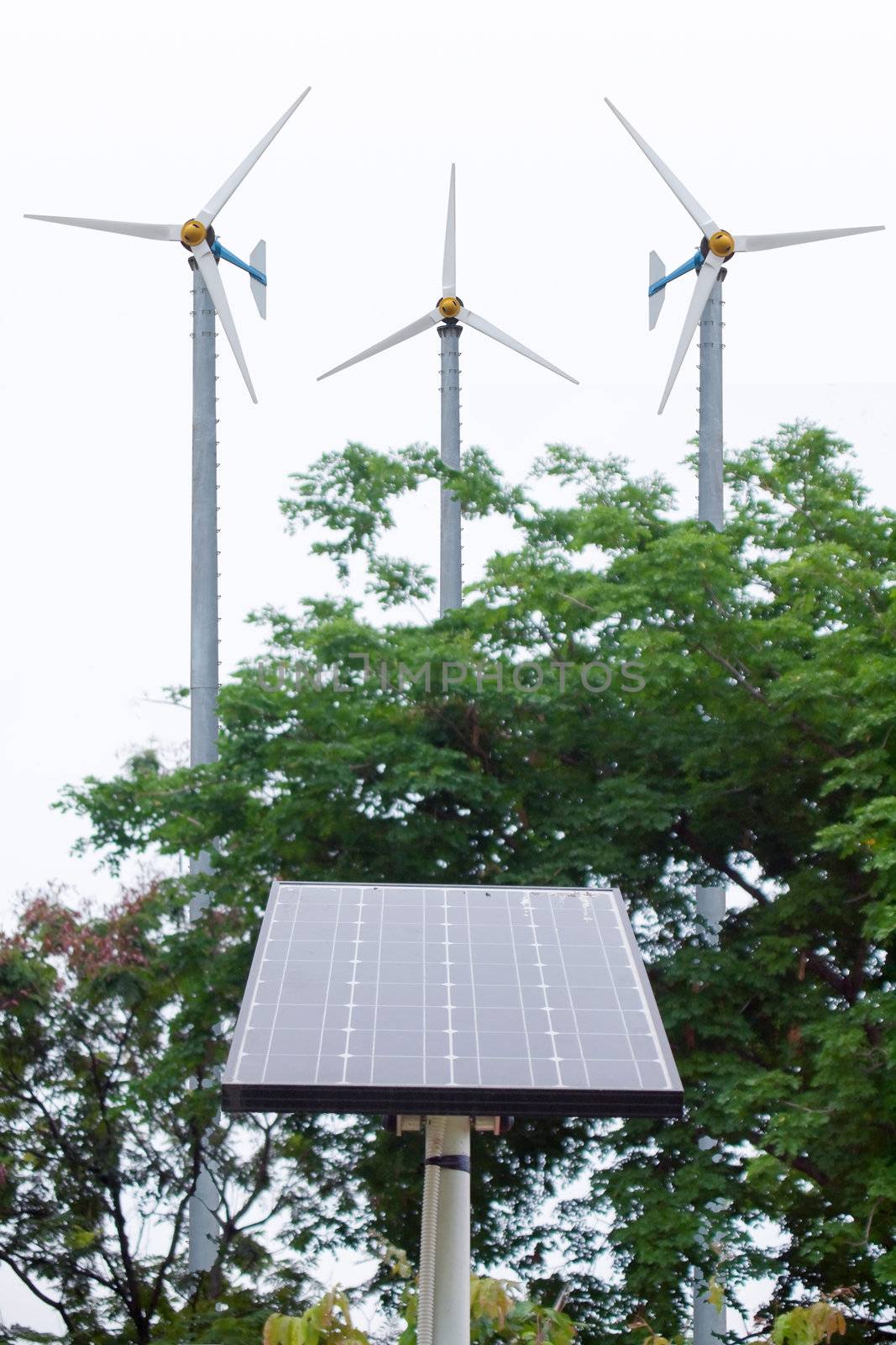 Solar energy panel and windmill in the background 