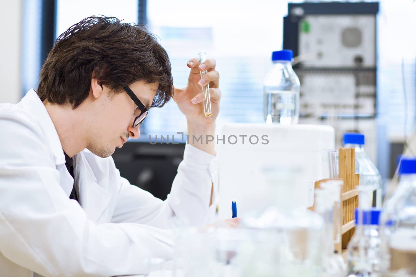 young, male researcher/chemistry student carrying out scientific research in a lab (shallow DOF; color toned image)