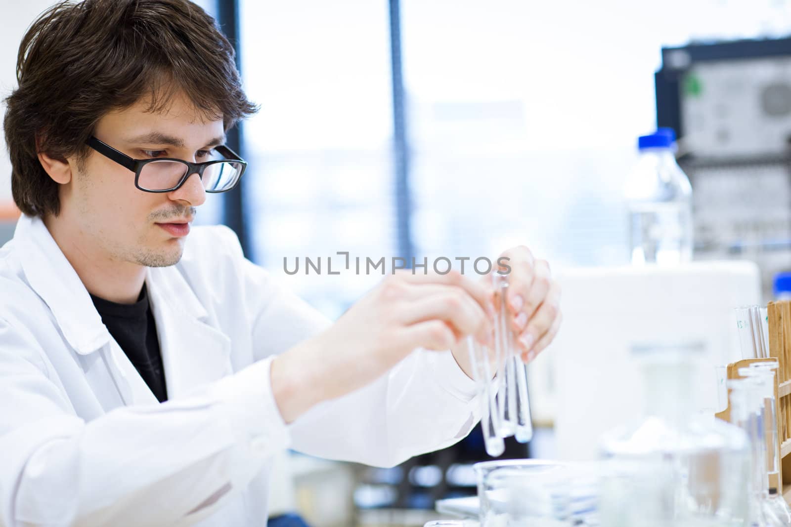 young, male researcher/chemistry student carrying out scientific research in a lab (shallow DOF; color toned image)