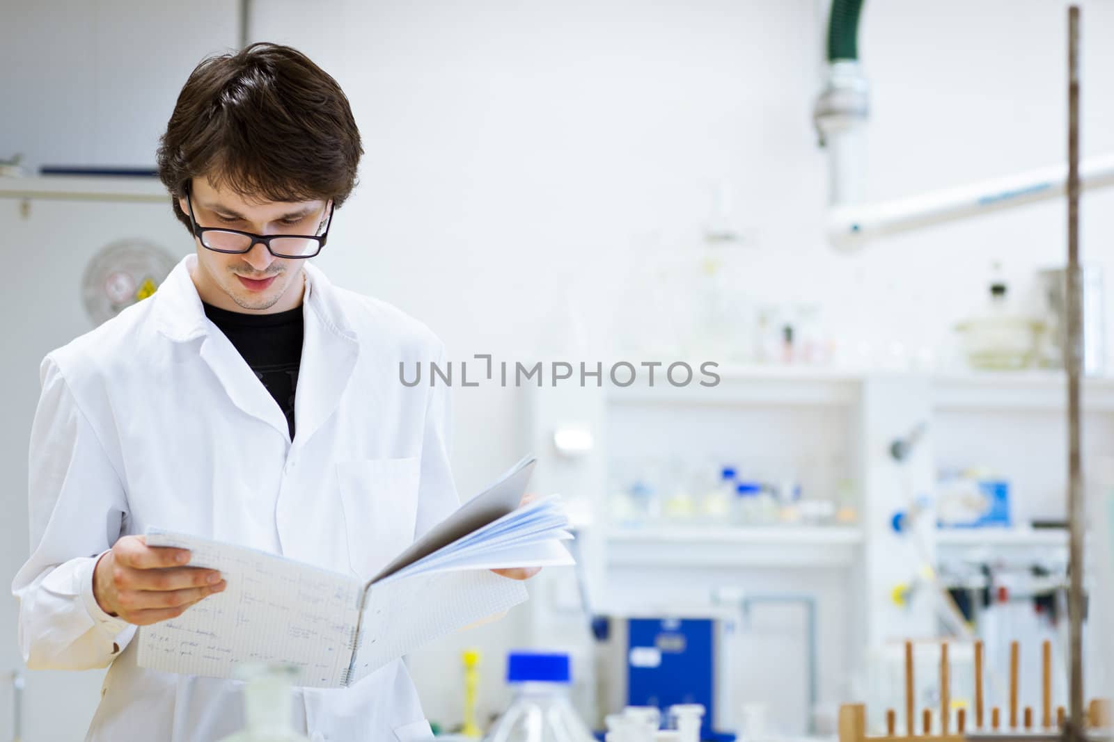 young, male researcher/chemistry student carrying out scientific research in a lab (shallow DOF; color toned image)