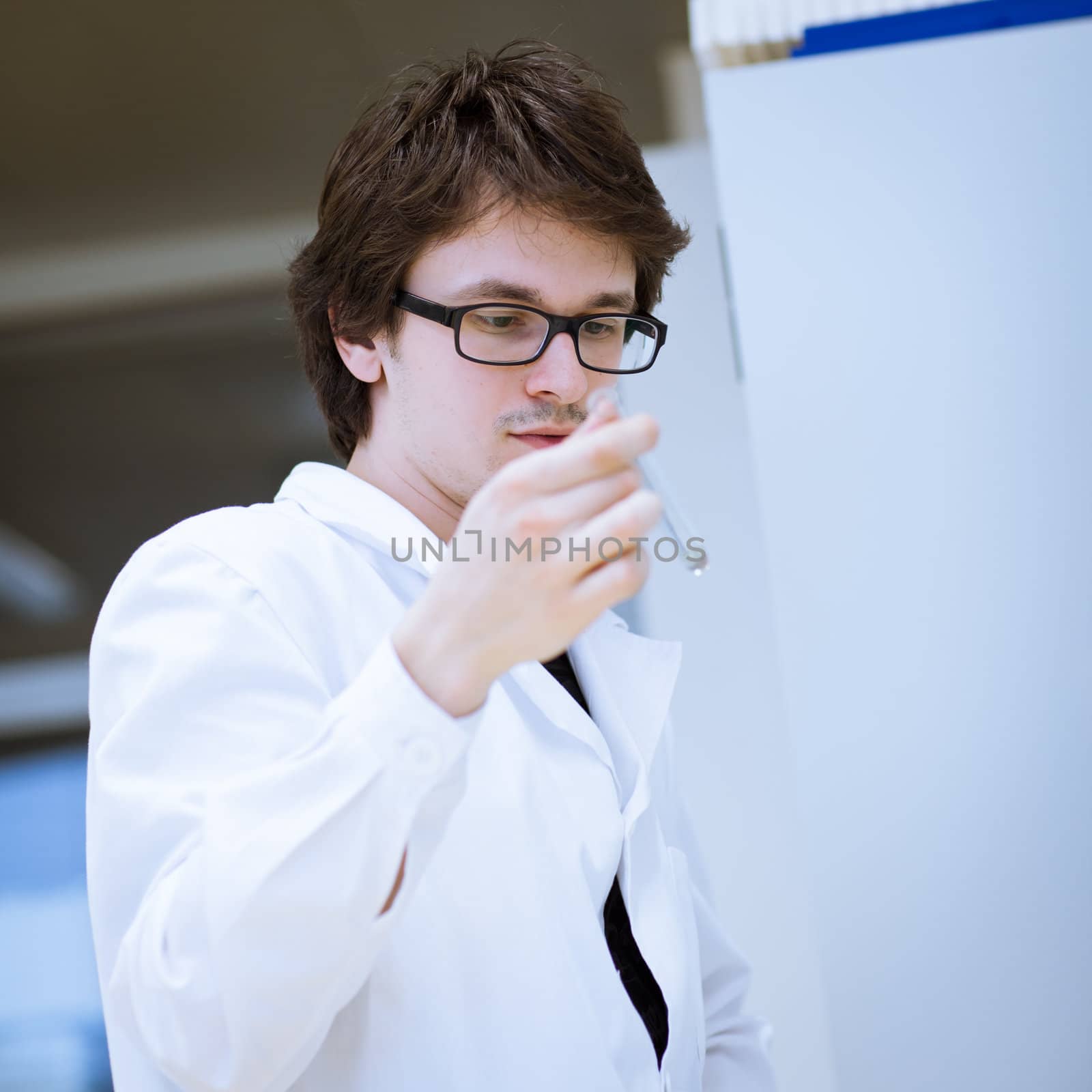 young, male researcher/chemistry student carrying out scientific research in a lab (shallow DOF; color toned image)