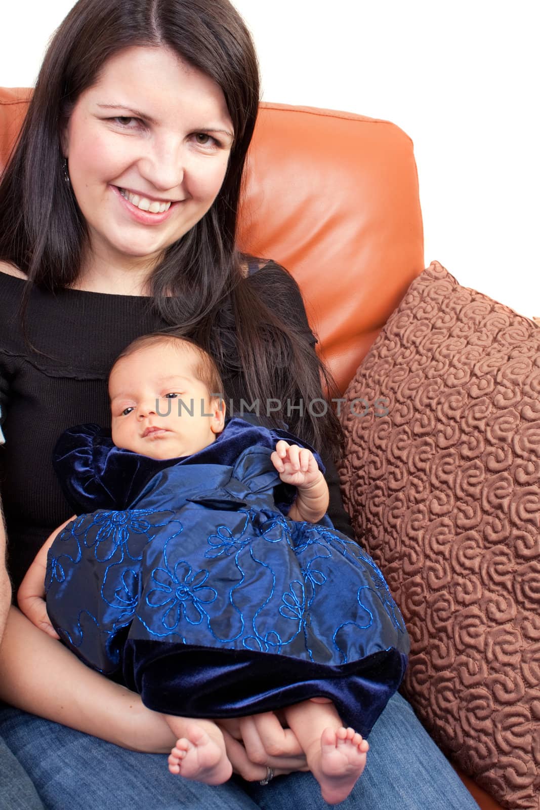 A newborn baby being held in the arms of her mother.