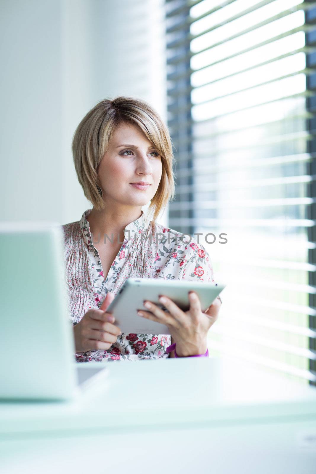 Pretty college student/businesswoman working on her tablet computer (shallow DOF; color toned image)