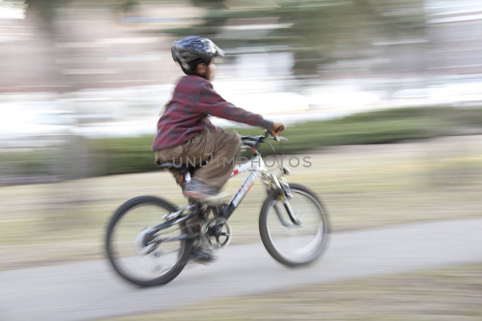 A young boy riding his mountain bike with motion blur 