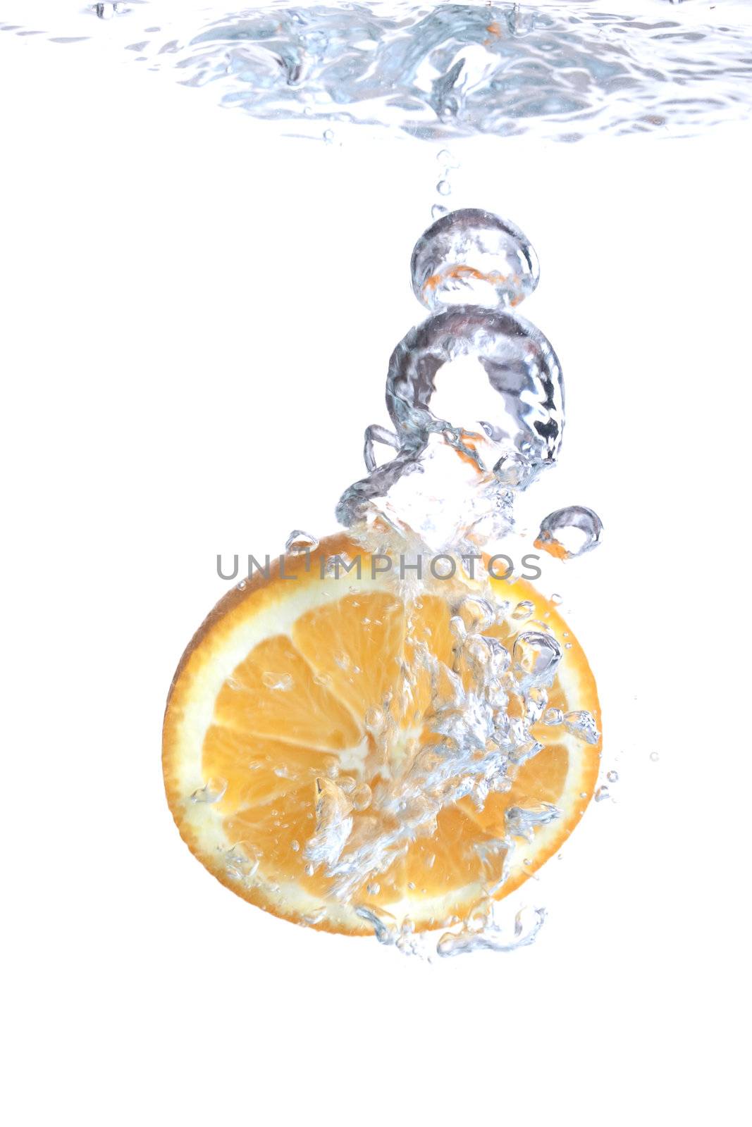 Orange falls into water on a white background