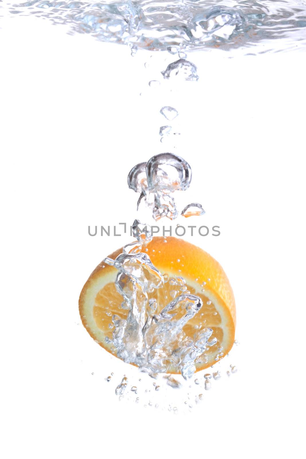 Orange falls into water on a white background