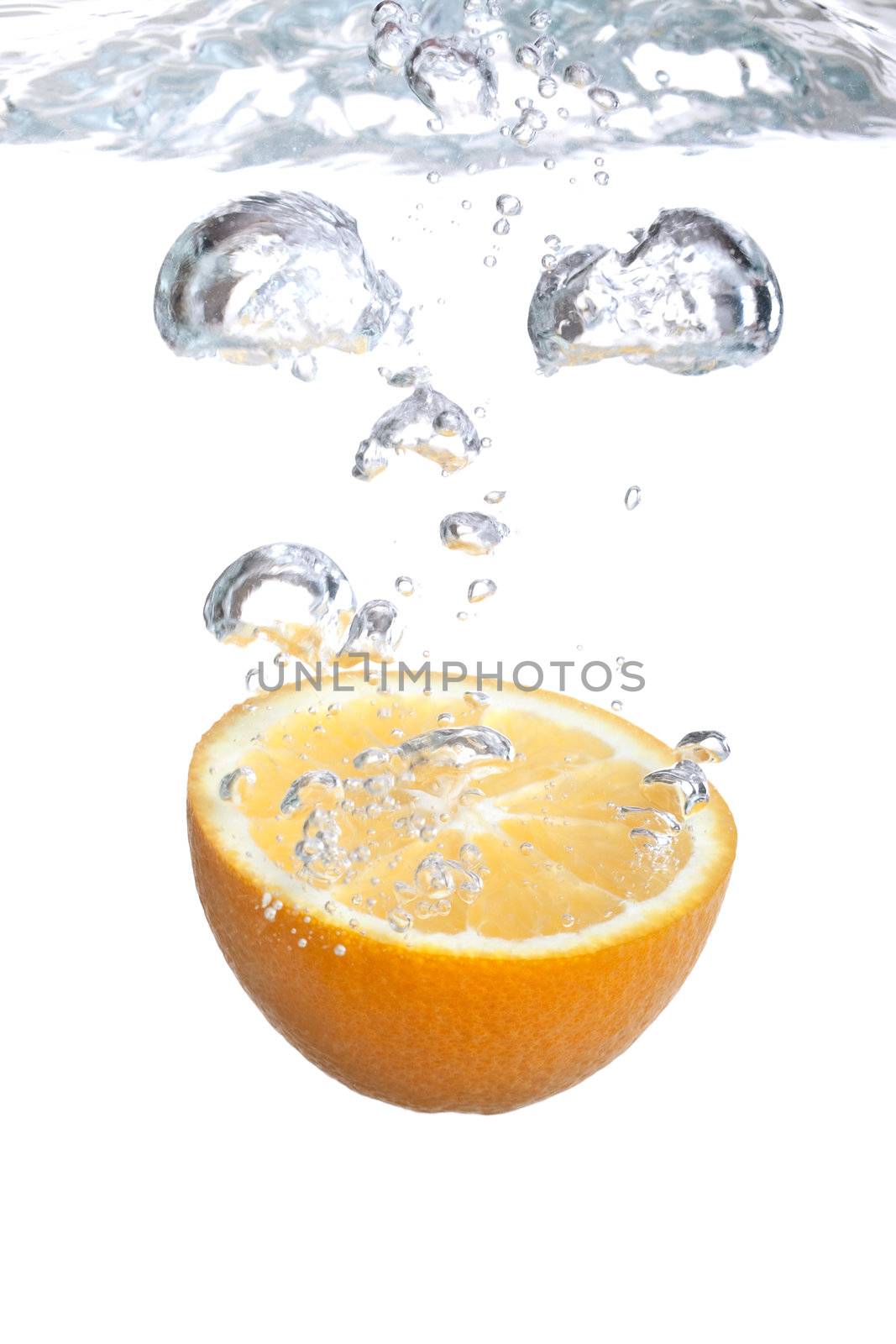 Orange falls into water on a white background