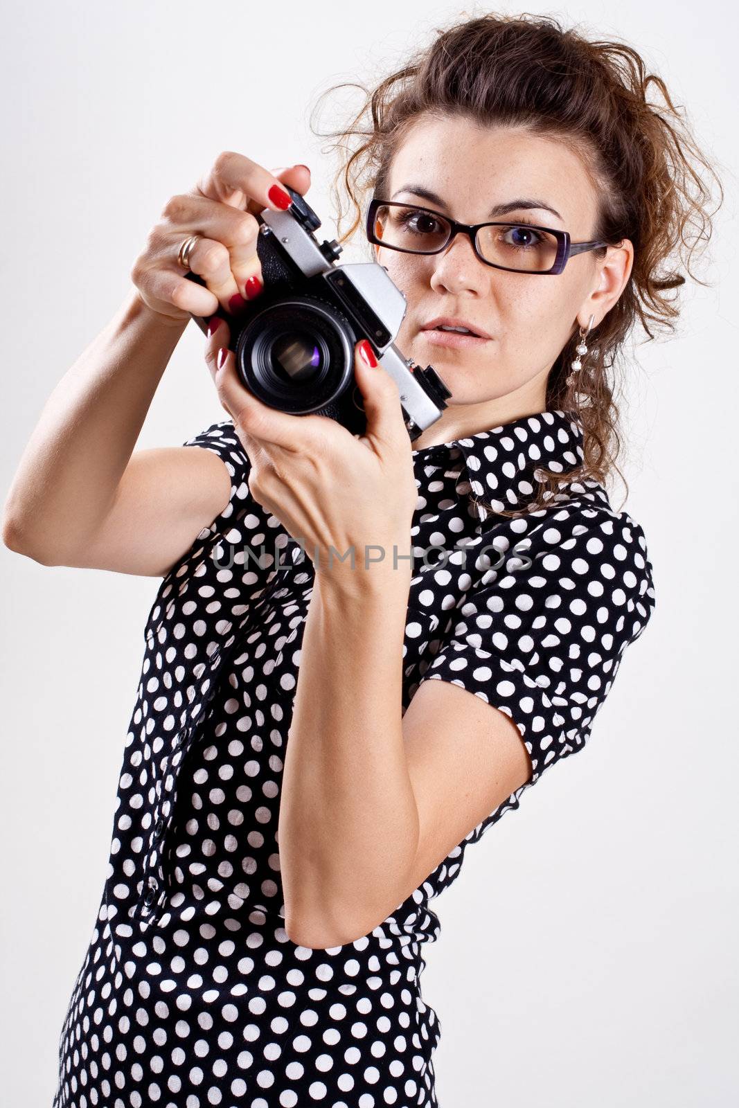 beautiful woman in a black polka dot dress with camera
