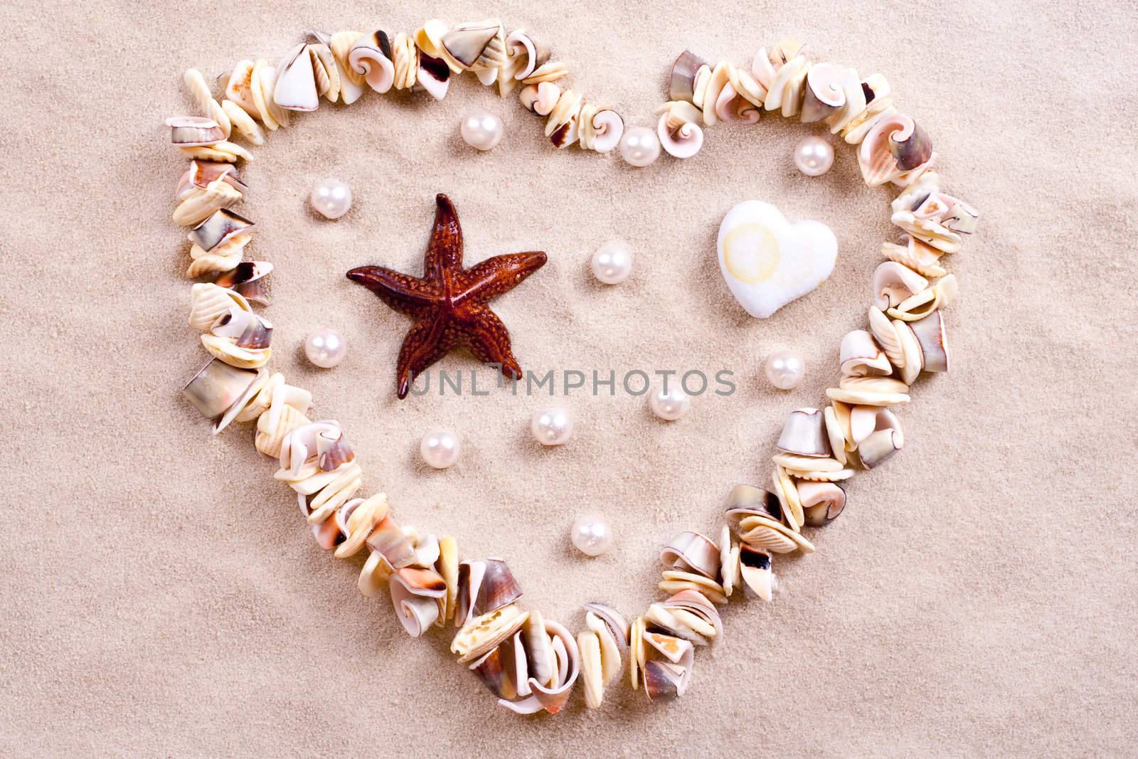 seashells in sand in the form of heart