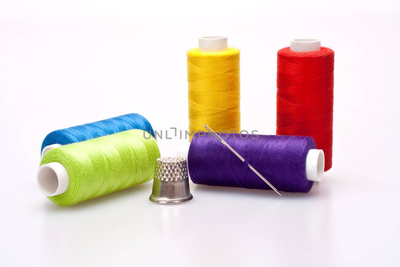multi-colored rainbow threads for sewing with needle and thimble