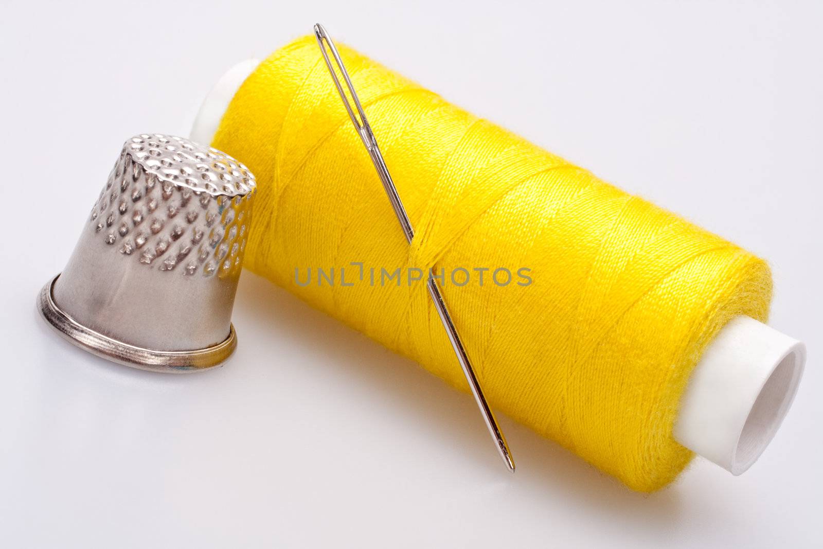 spool of thread for sewing with needle and thimble 