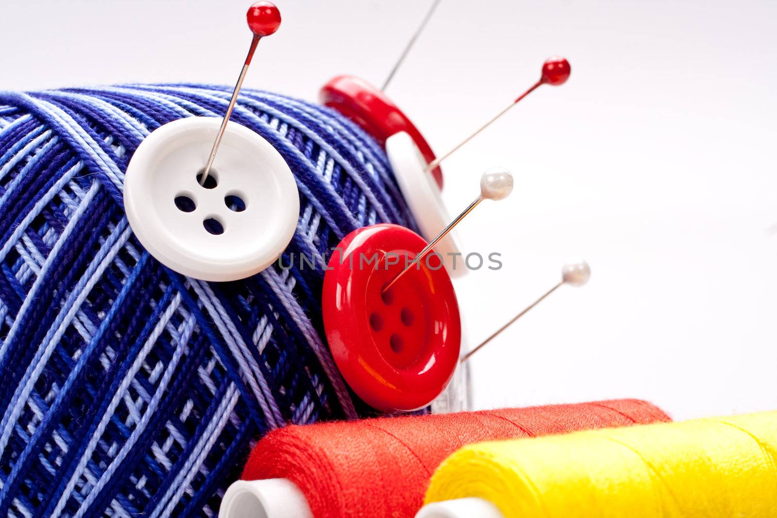 red and white pins in wool ball with buttons