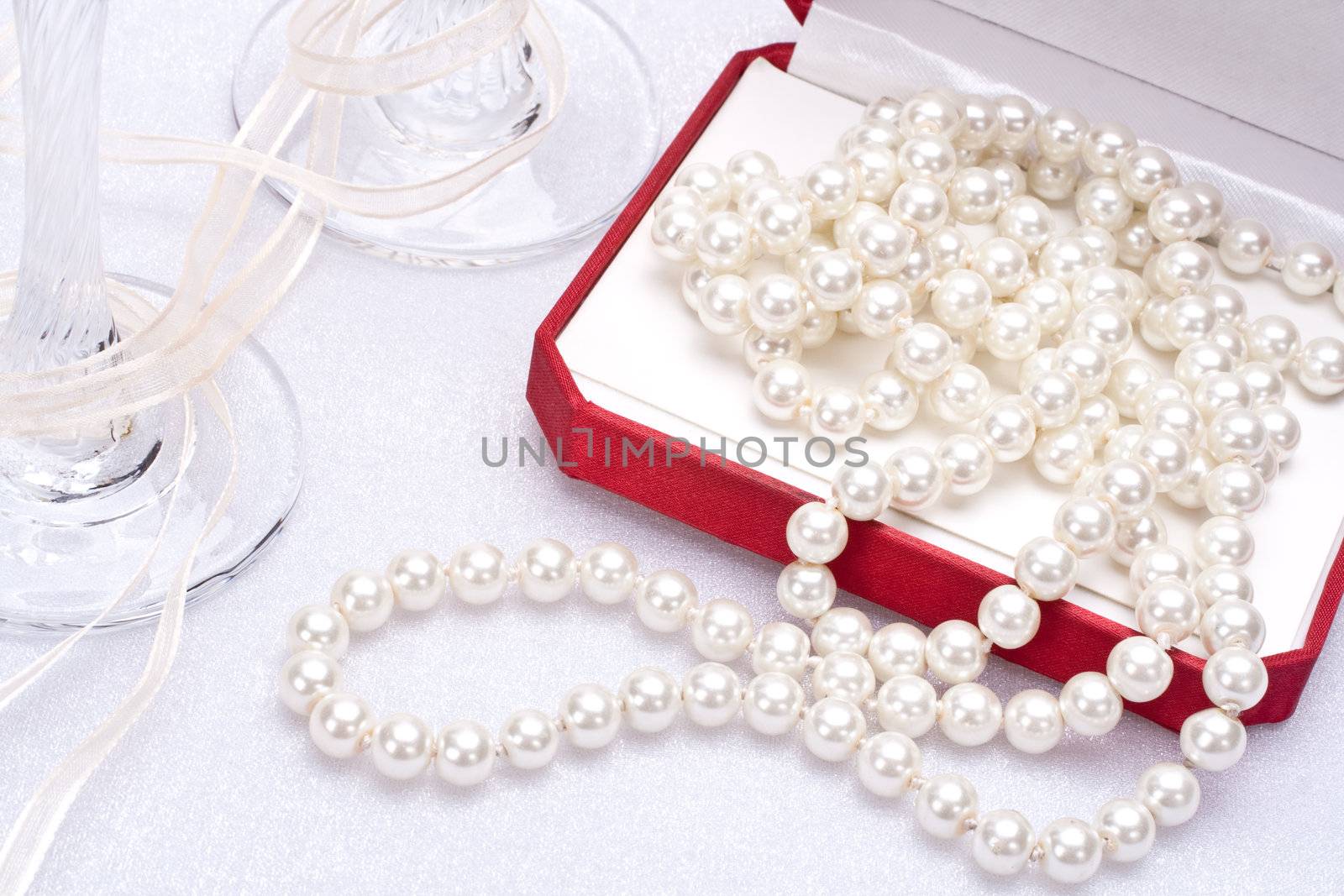 pearls in a red gift box with glasses