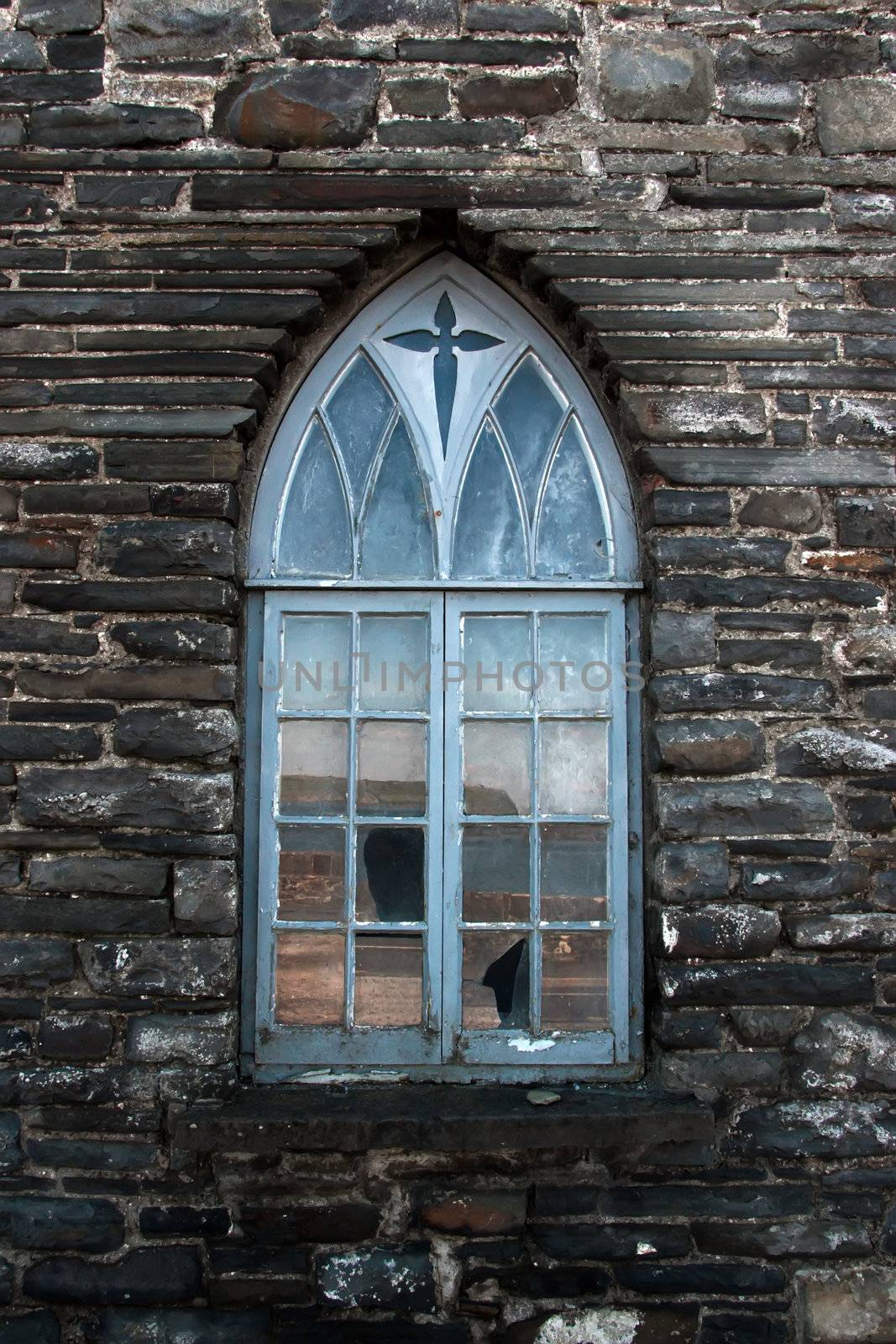 an old castle arch shaped window against a stone wall