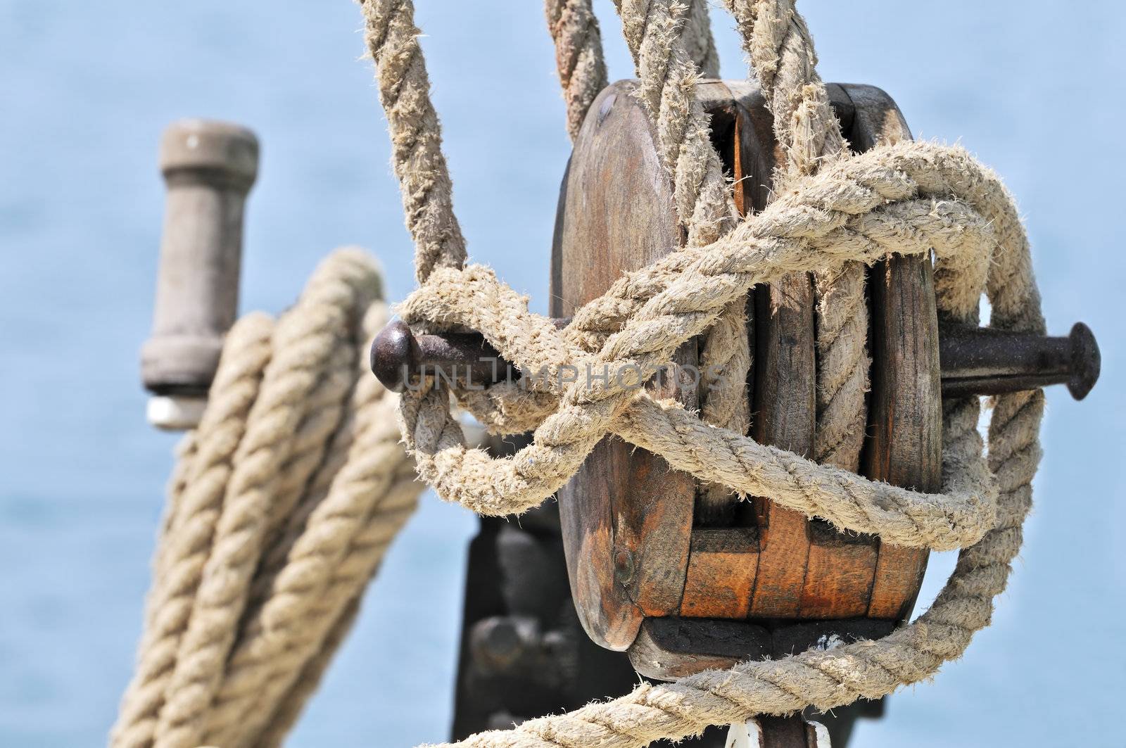 Close-up of a wooden block, winch and  rigging of an old sailboat