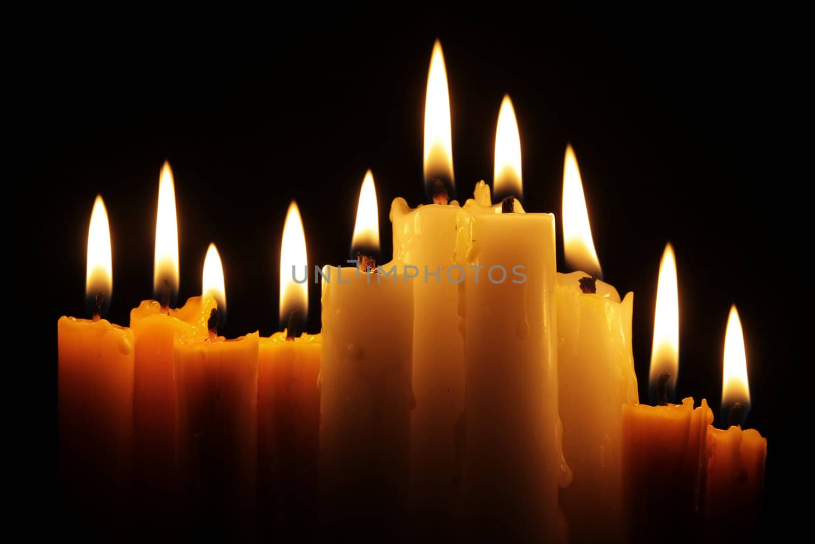 line of burning candles in the dark