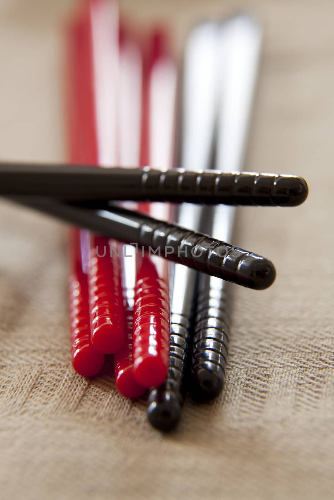Four sets of plastic chopsticks in black and red.