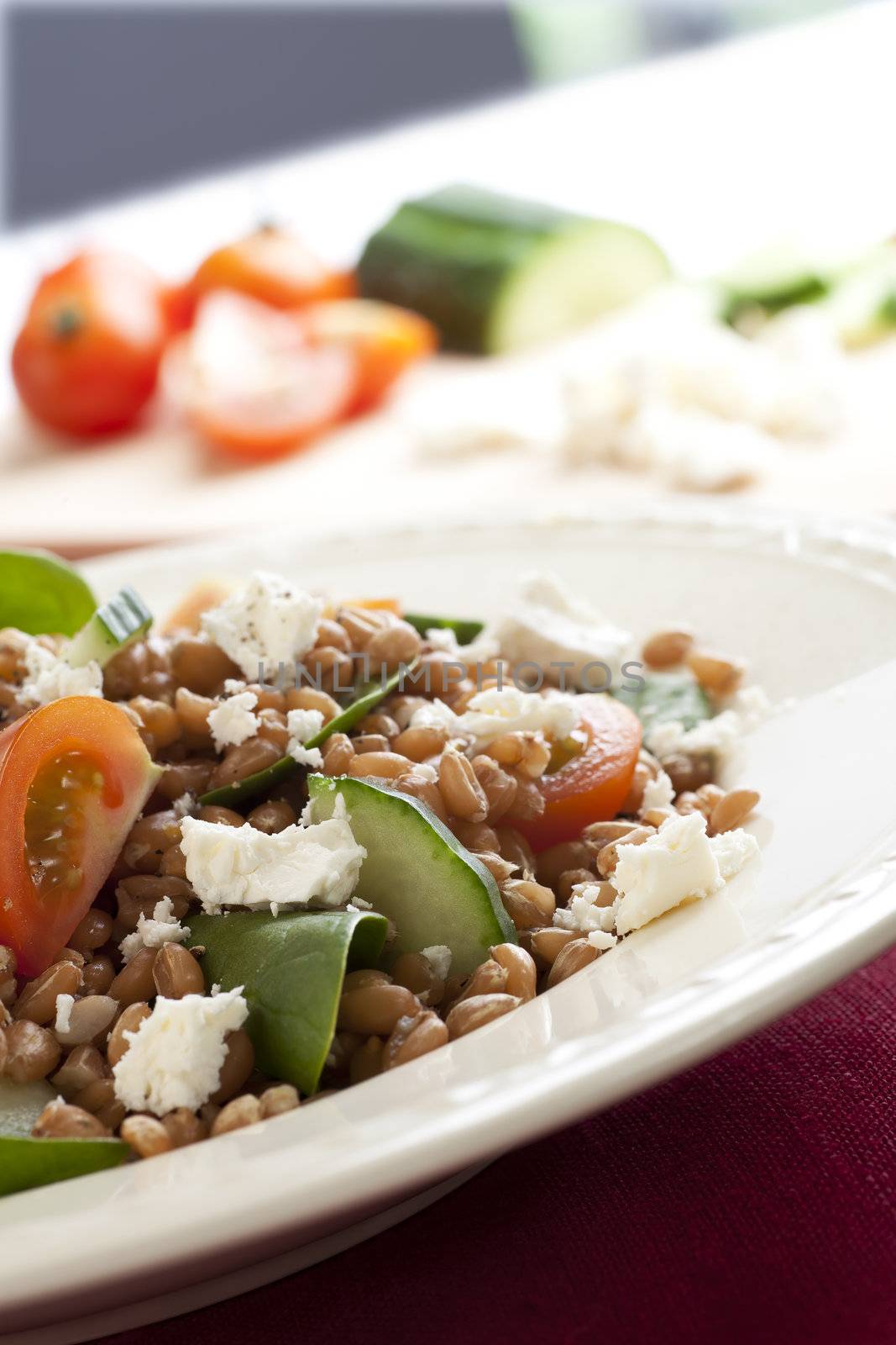Fresh salad with spelt wheat berries, spinach, tomatoes, cucumbers and feta cheese.