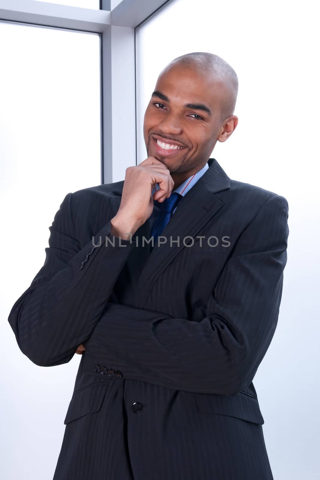 Portrait of a smiling charismatic businessman beside a window.