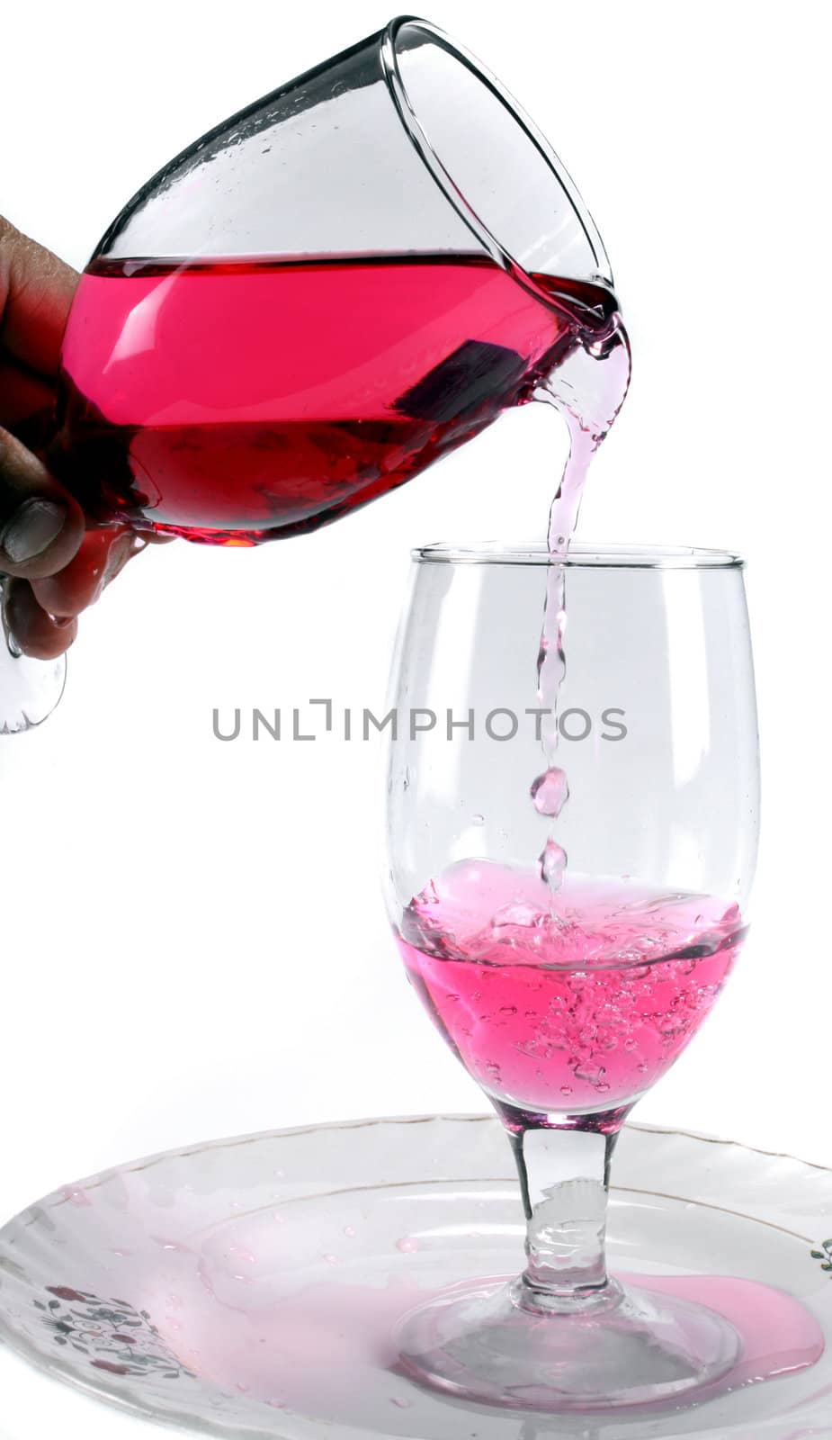 A concentrated red flavor being poured in a glass to make cocktail.