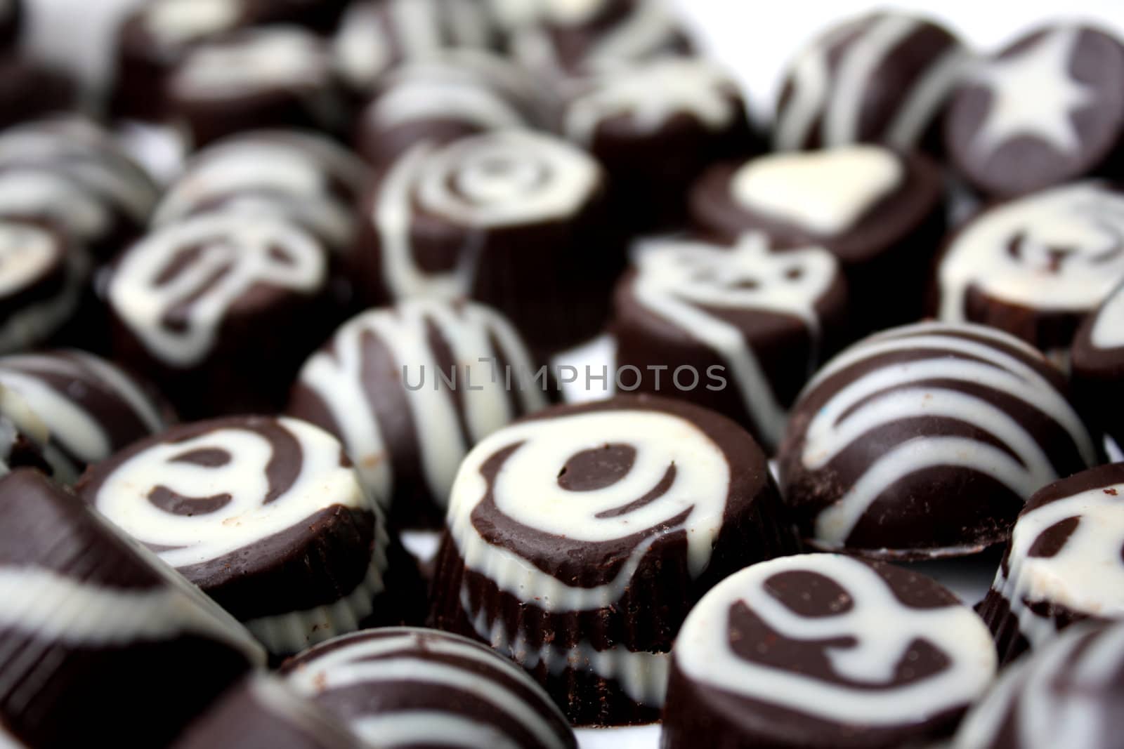 A background of delicious looking chocolates with a white design.