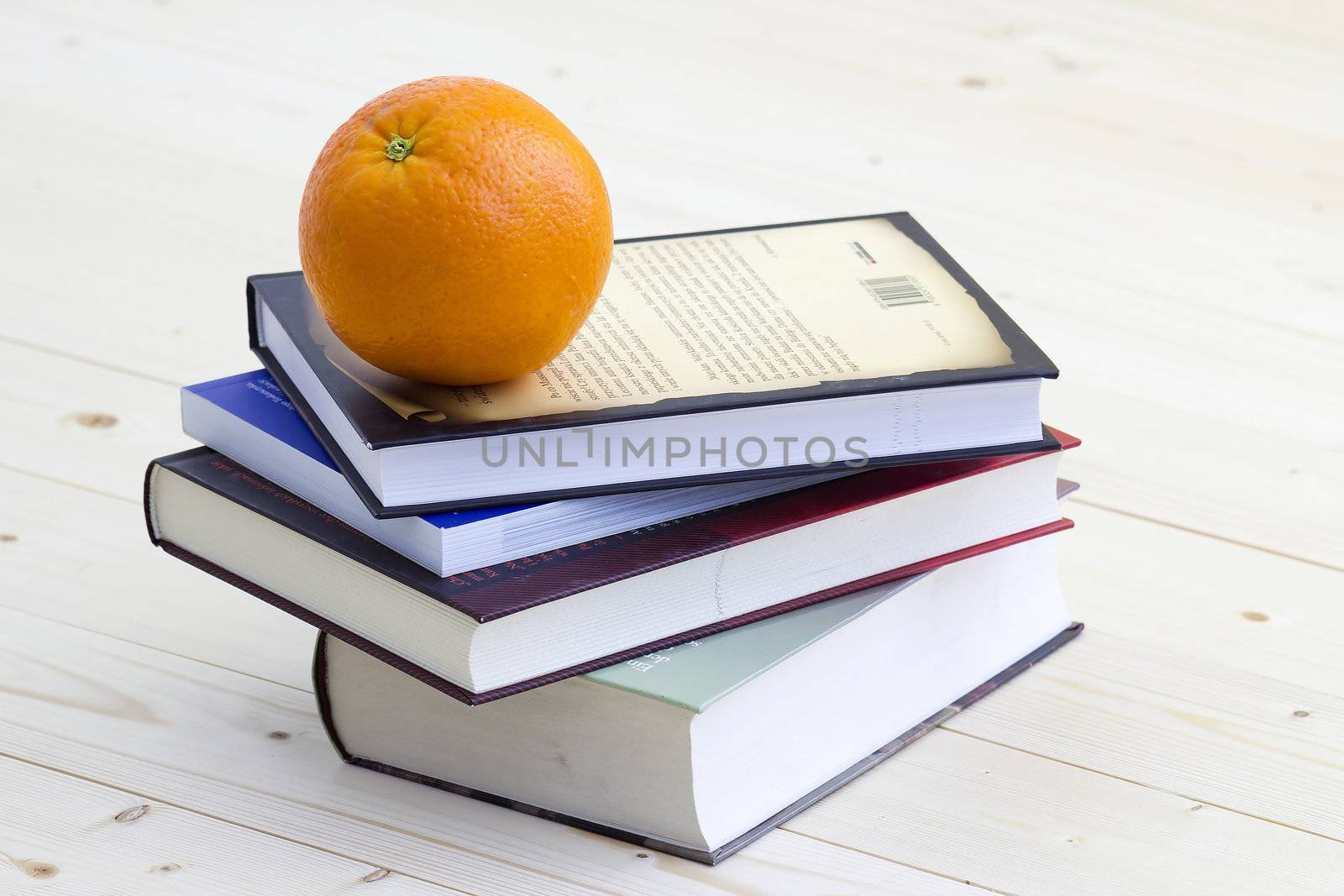 stack of books and fresh orange