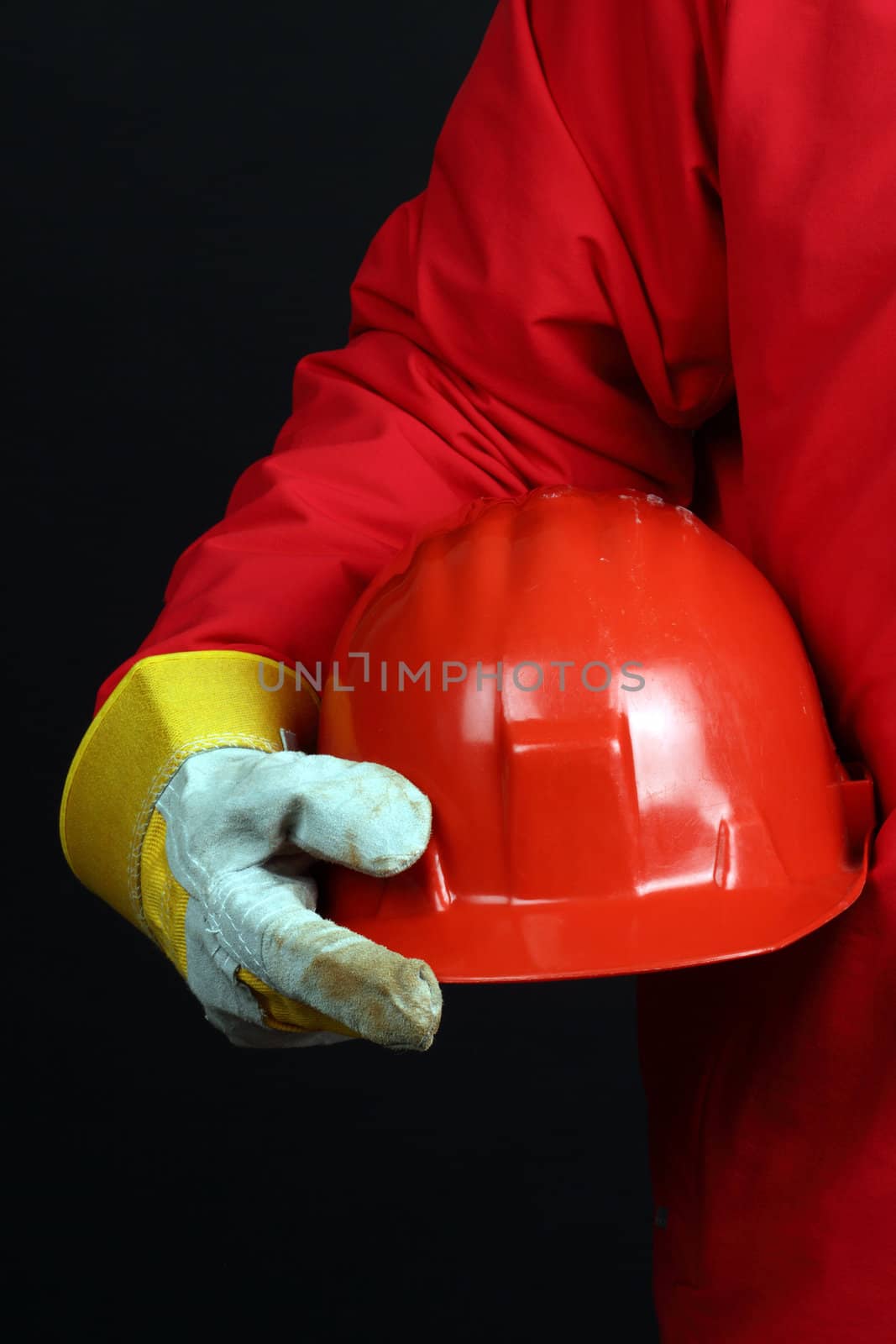 man holding red helmet over black background