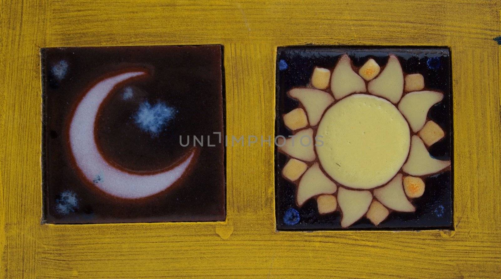 Sun and moon symbols crafted in ceramics and framed in wood