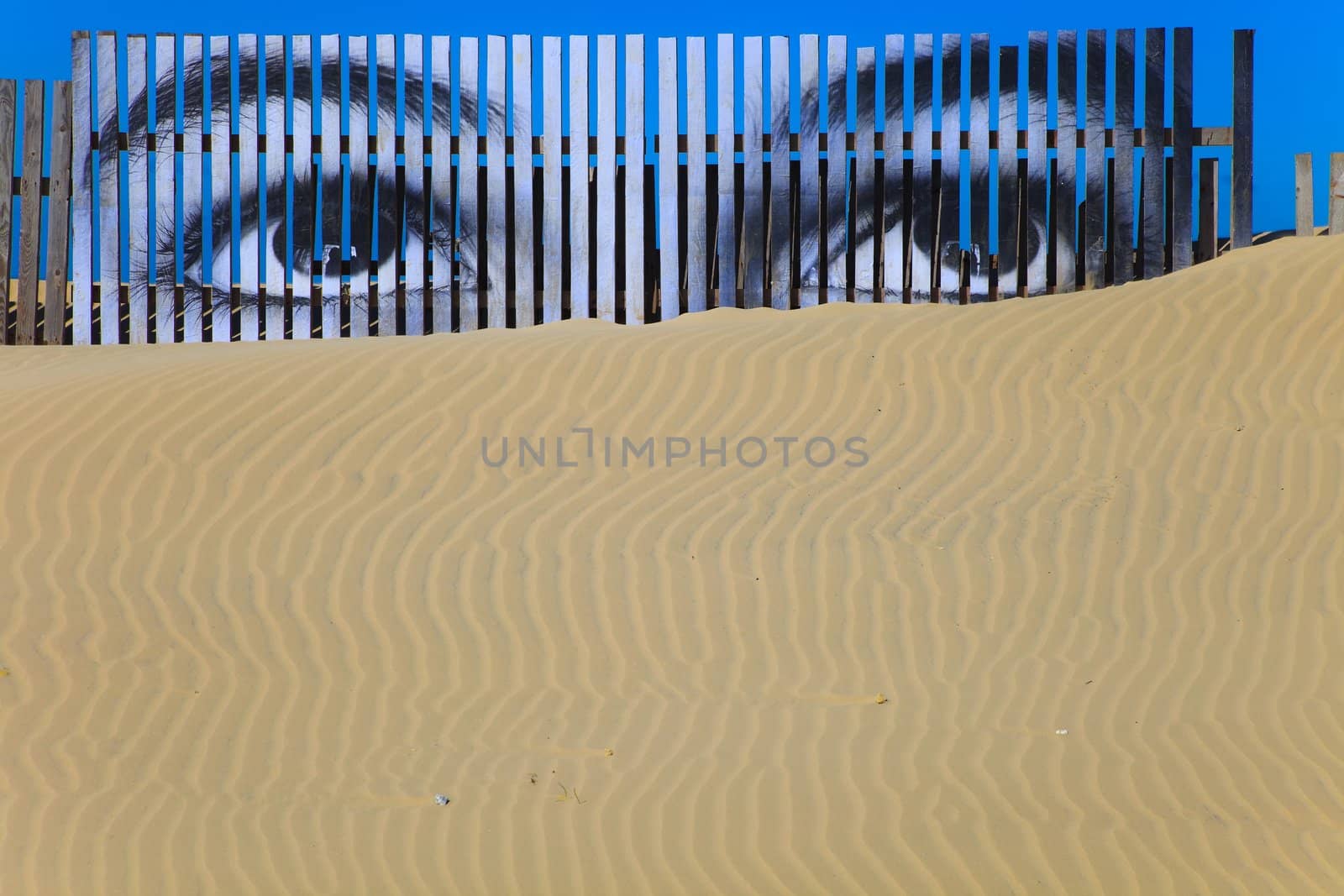 Superposed eyes on the boards of a dune of Cortadura's beach ( Cadiz )