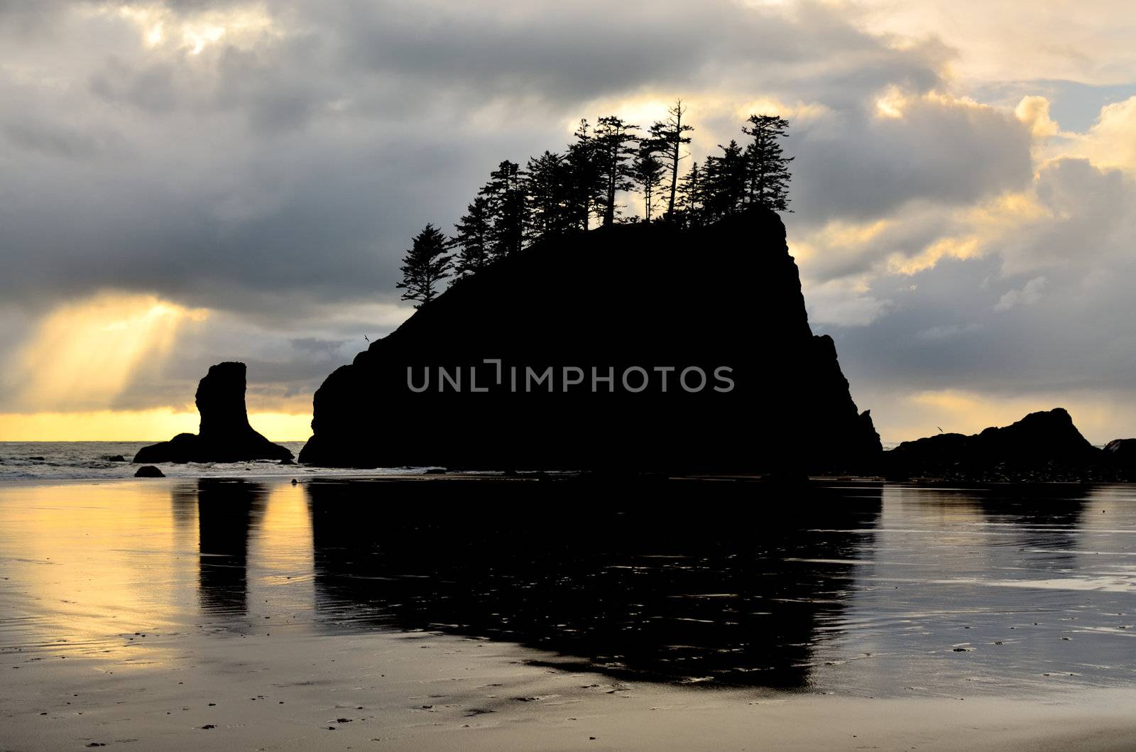 Silhouette of Sea Stack at Second Beach. A shaft of light breaks through the clouds.