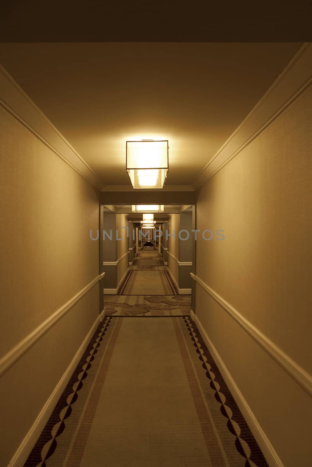 A long modern hotel hallway with rooms on either side